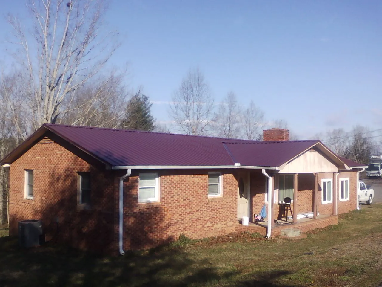 Burgundy metal roof on a brick ranch home with a new addition in South Park