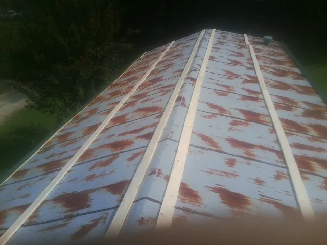 Rusted metal roof panels with new wood purlins before replacement — Storm Damage Roof Repair in South Park by Roofing Brothers