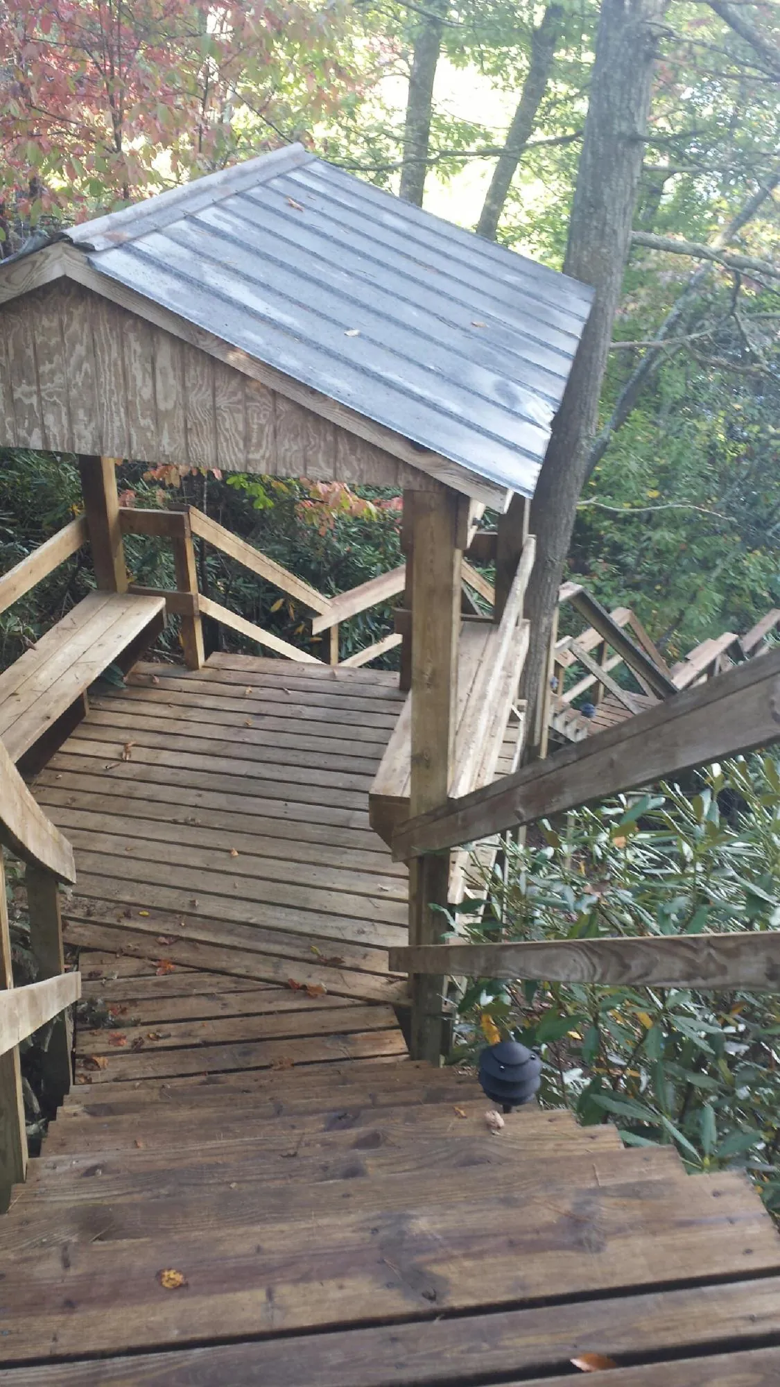 Metal roofed shelter over wooden steps on a wooded walkway — Skylight Repair & Installation work by our crew in South Park
